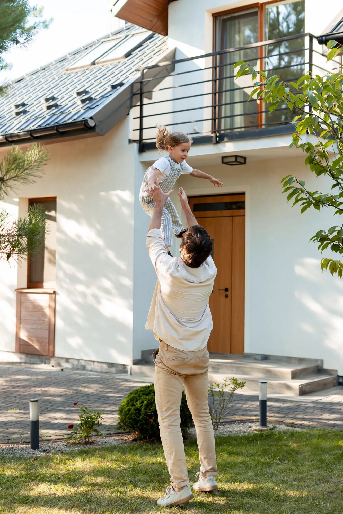 father and daughter playing outside in front of house